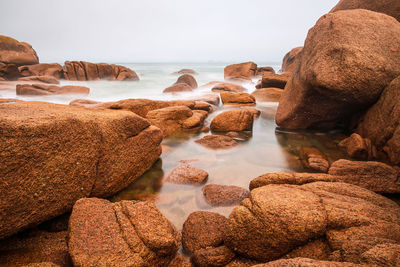 View of rocks on beach against sky