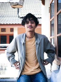 Portrait of young man sitting on building