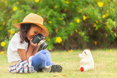 Girl wearing hat sitting in grass