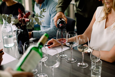 Cropped image of businessman pouring red wine in glass at convention center