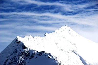 Low angle view of snowcapped mountains against sky