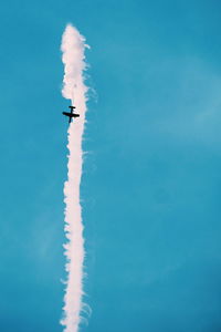 Low angle view of airplane flying against blue sky