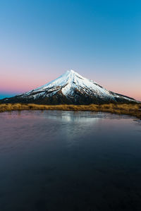 Scenic view of lake against mountain during sunset