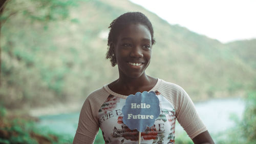 Portrait of smiling young woman standing outdoors