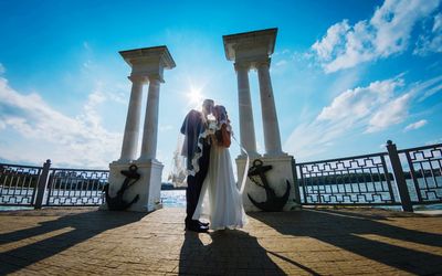 Couple kissing at beach against blue sky