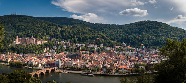 Scenic view of townscape and mountains against sky