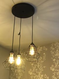 Low angle view of illuminated pendant light hanging from ceiling