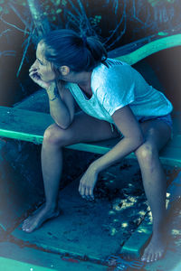 Woman sitting on seat in park