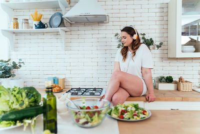 Woman having food in kitchen at home