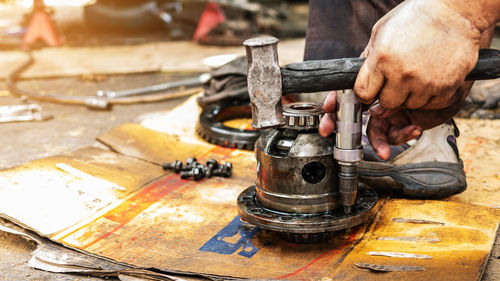 Technicians are using the tools to disassemble the gears of the drive shaft of cars.