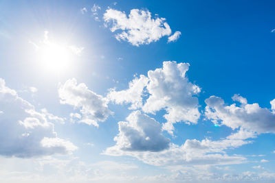 Low angle view of sunlight streaming through clouds