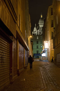 Man walking on illuminated street at night