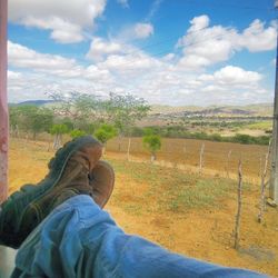 Low section of man on landscape against sky