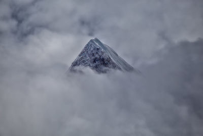 Low angle view of snowcapped mountain against sky