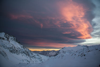 Scenic view of snowcapped mountains against sky during sunset