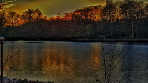 Scenic view of lake against sky at sunset