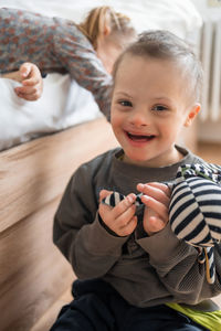 Portrait of boy sitting on hardwood floor