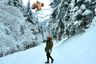 Rear view of woman walking on snow covered mountain