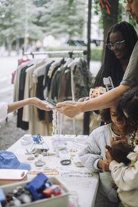 Man doing contactless payment while doing shopping near stall at flea market