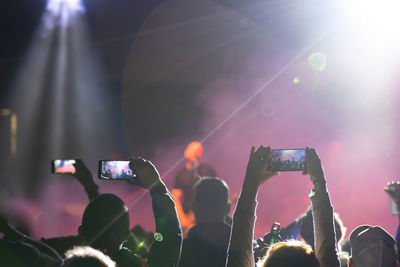 Group of people photographing at music concert