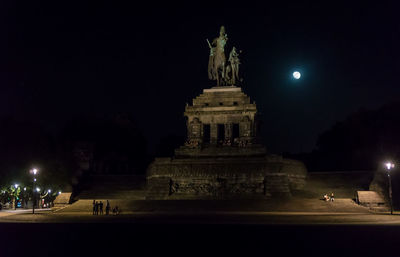 Statue in city at night