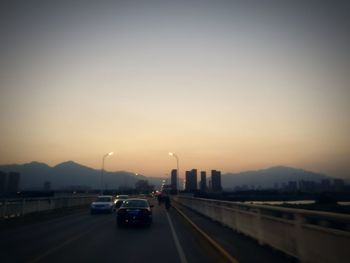 Cars moving on road at sunset