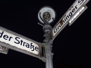 Close-up of road sign at night