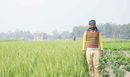 Portrait of man standing in agricultural field