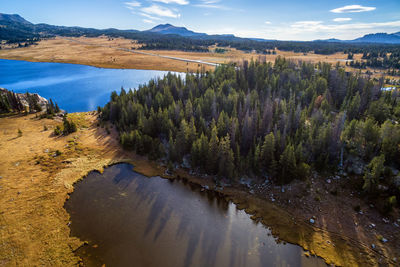 Scenic view of river by mountains against sky