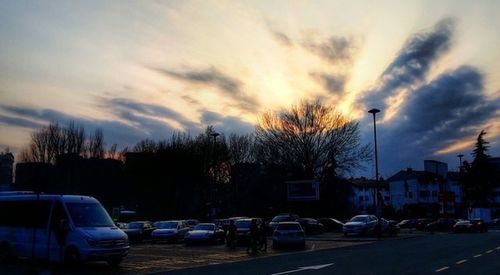 Cars on road against cloudy sky