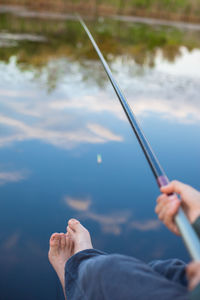 Low section of boy fishing in lake