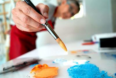 Painter showing paint brush at workshop