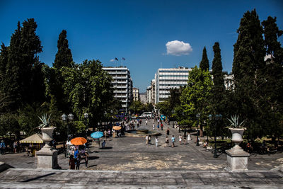 People on street in city against sky