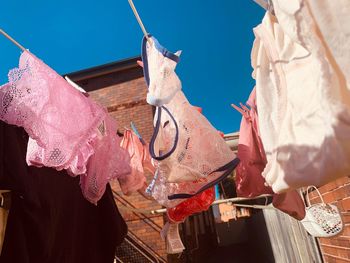 Low angle view of clothes drying on clothesline against sky