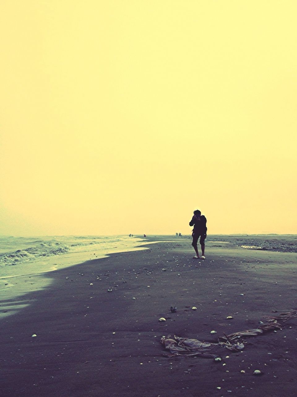 beach, sea, copy space, clear sky, horizon over water, full length, shore, sunset, lifestyles, water, leisure activity, silhouette, sand, men, tranquil scene, walking, standing, tranquility