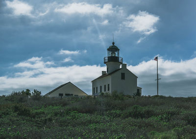 Low angle view of lighthouse amidst buildings against sky