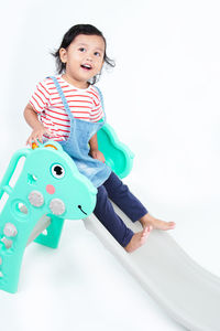High angle view of cute girl playing with toy on white background
