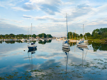 Sailboats moored in lake against sky