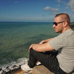 Side view of young man looking at sea