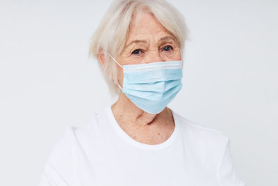 Portrait of woman wearing mask against white background