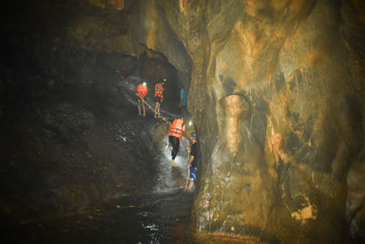Rear view of person on rock formation in cave