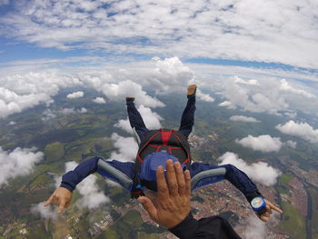 Man paragliding over mountain against sky