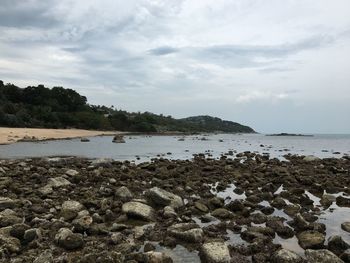 Rocks on beach against sky