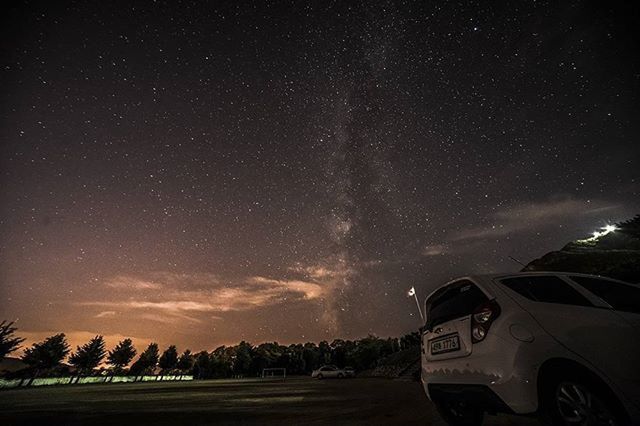 transportation, car, mode of transport, night, sky, land vehicle, road, tree, scenics, landscape, beauty in nature, nature, travel, cloud - sky, on the move, tranquil scene, windshield, star - space, outdoors, street