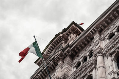 Low angle view of flag on building against sky