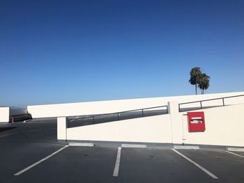 Empty parking lot against clear blue sky