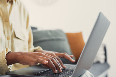 Midsection of woman using laptop on table