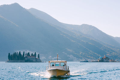 Boat in sea against mountain