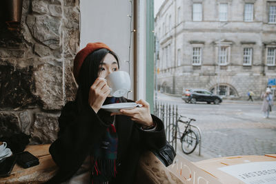 Chinese girl sitting in a cafe drinking coffee