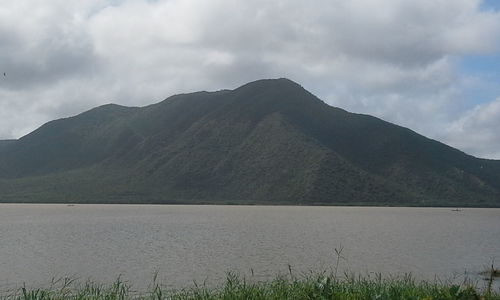 Scenic view of lake and mountains against storm clouds